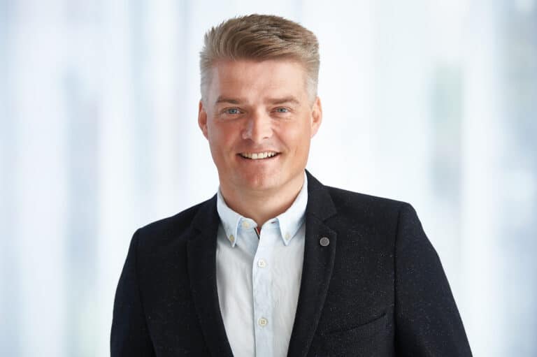 Mann in Anzug lächelnd, aufgenommen im Fotostudio Winterthur. Ideal für Videoproduktion und Filmstudio.