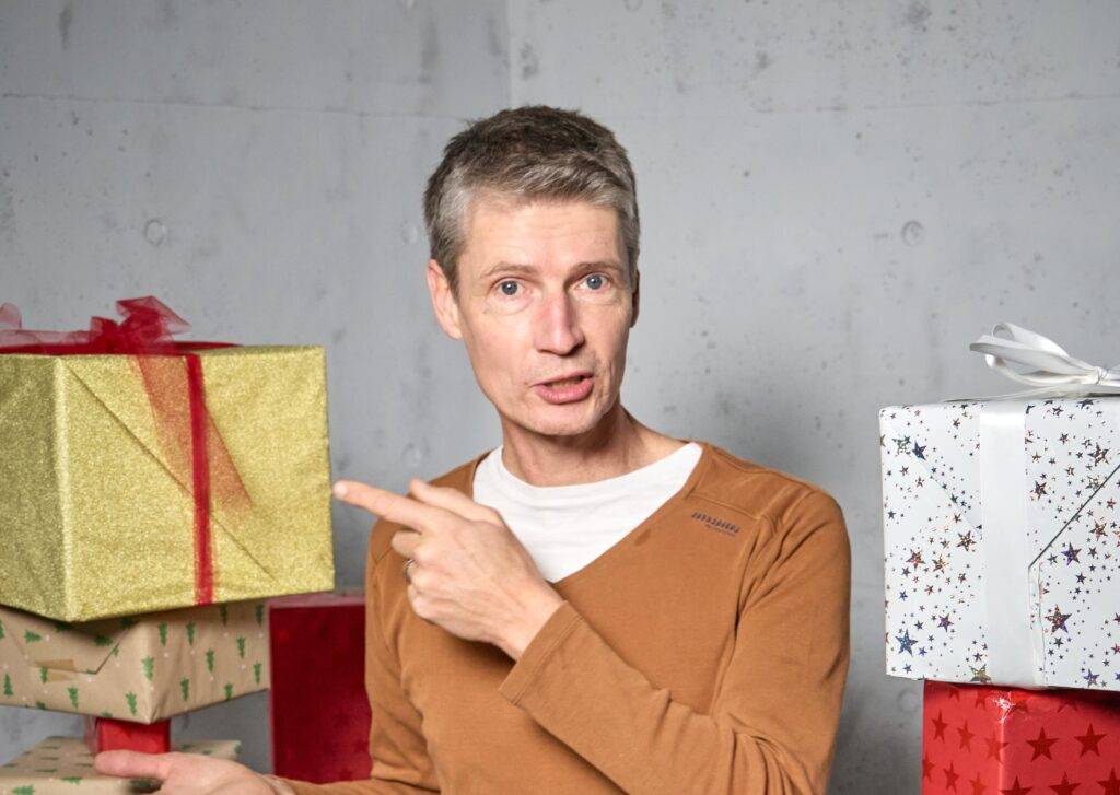 Mann zeigt auf Geschenke, ideal für Weihnachts-Fotostudio oder Filmstudio, Winterthur.